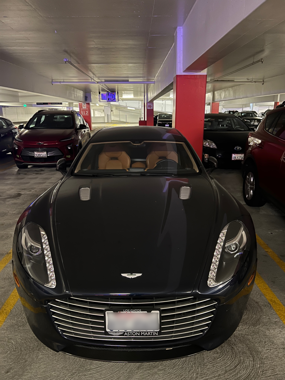 Black Aston Martin parked in an underground garage